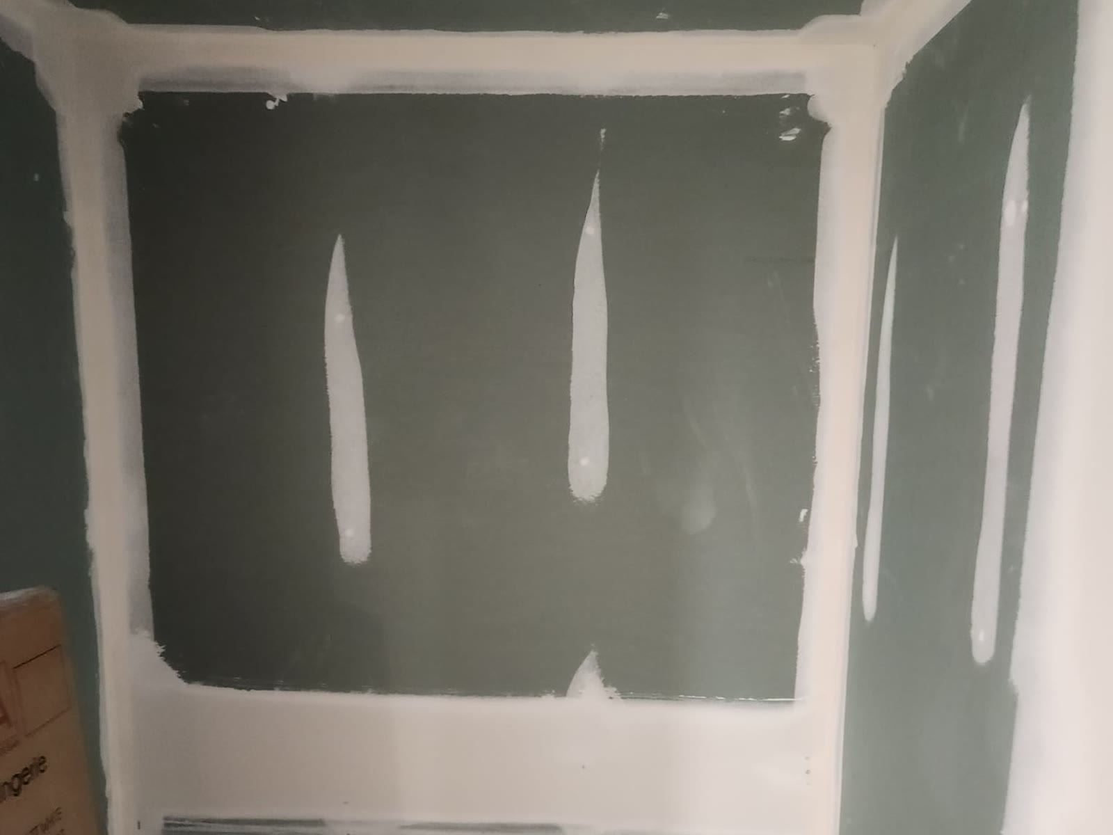 Green moisture-resistant drywall with taped seams and inside corners and mudded screw holes